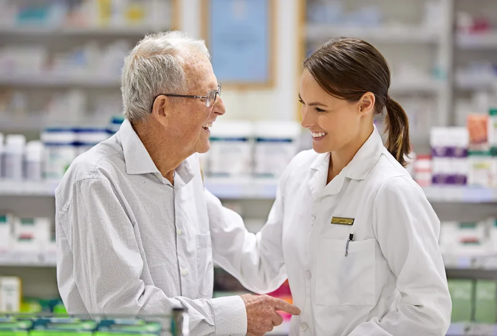 friendly pharmacist assisting senior man