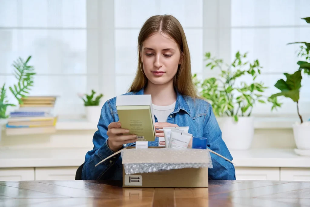 young woman unboxing new beauty products at home