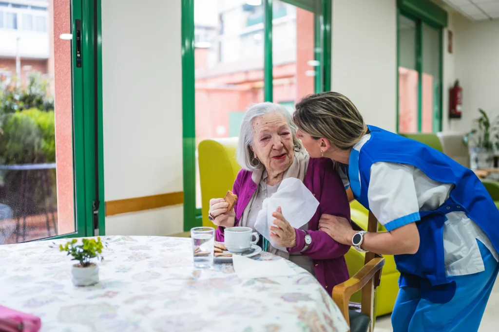 woman with caregiver sharing a snack indoors